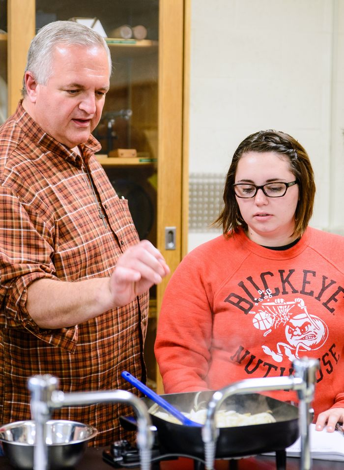 SHU Assistant Professor of Chemistry Julius Nagy (left) assists students during a culinary chemistry classroom cooking project.